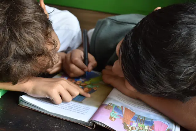 Two children reading a picture book together