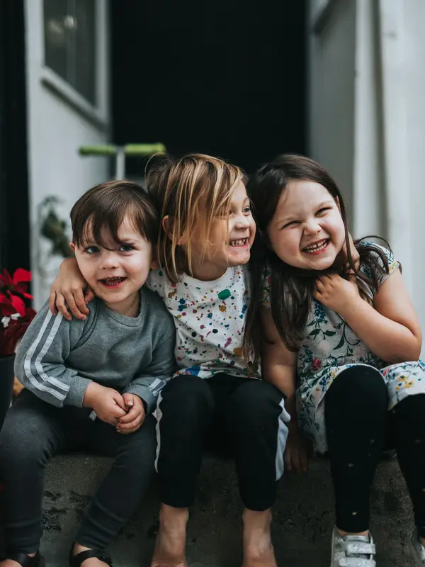 Three smiling children embracing